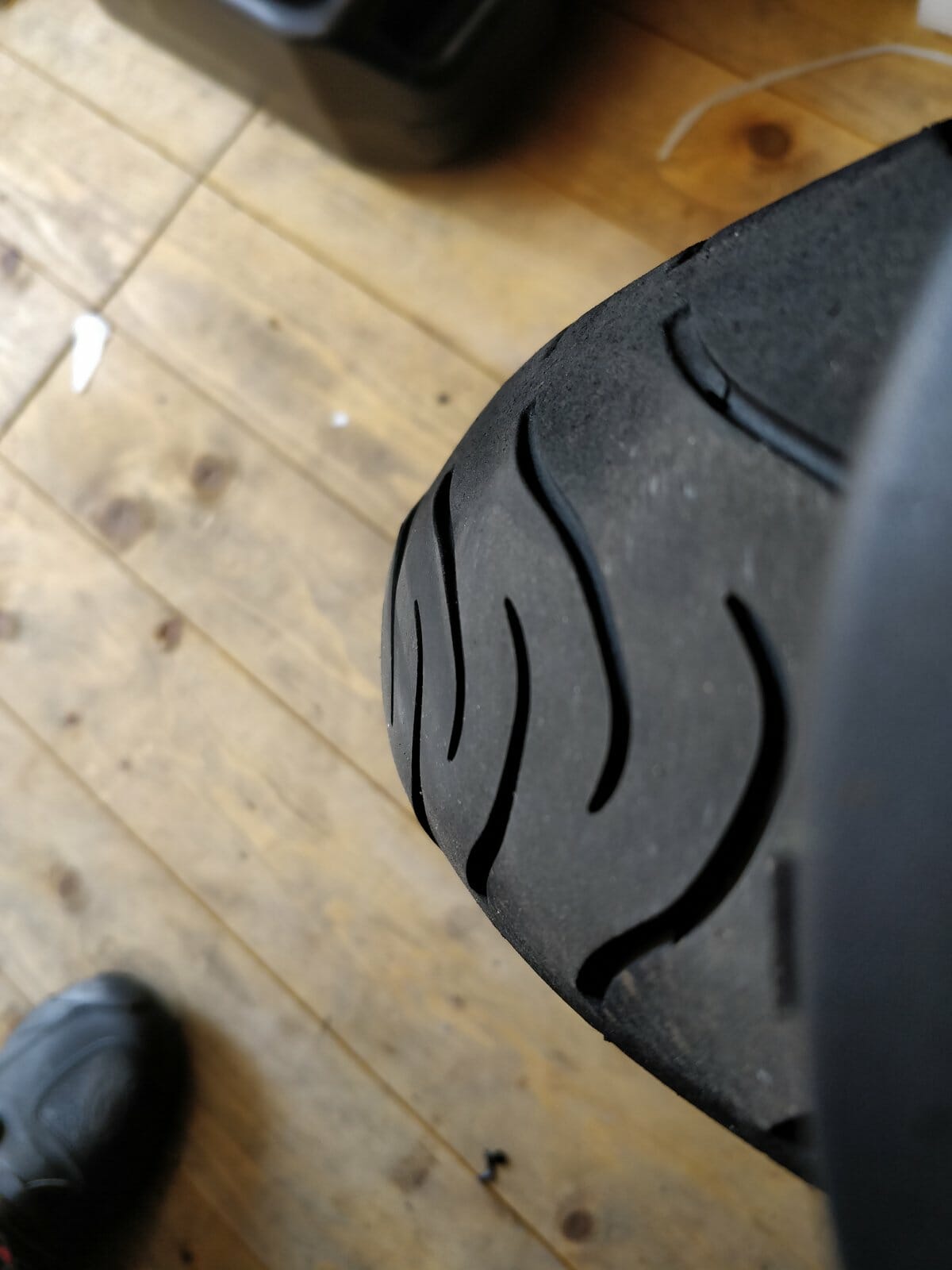 In a motorcycle which tyre wears faster the rear or the front