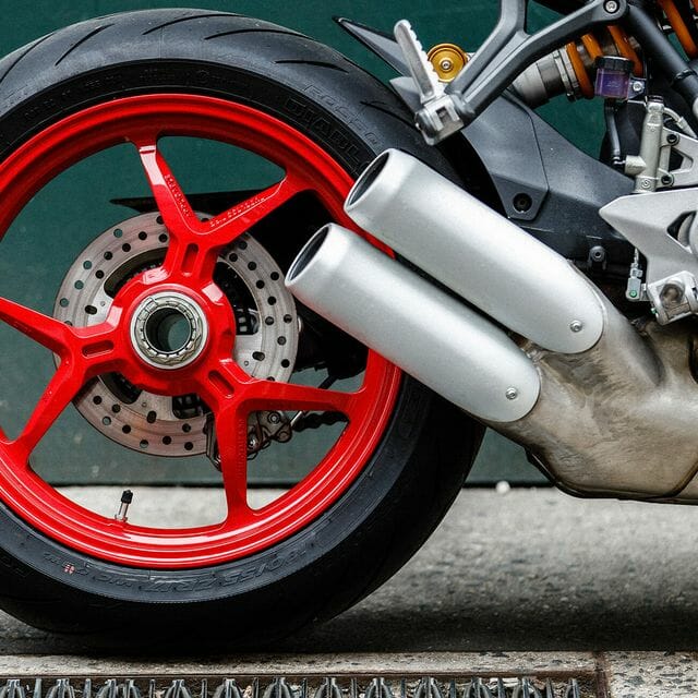 What are the pros and cons of a wide back tire on a motorcycle
